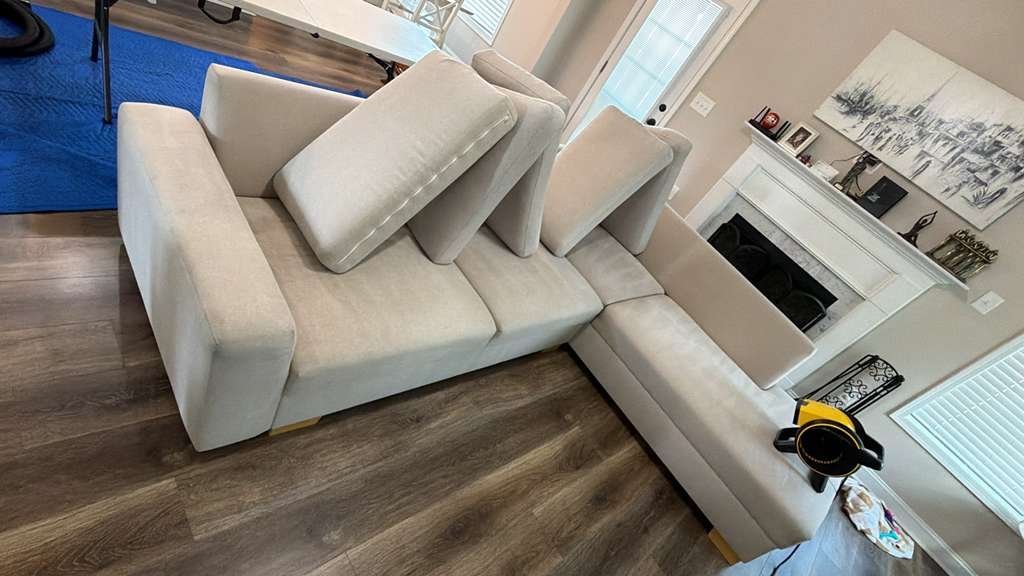 A cream sectional sofa being cleaned with an air mover drying the cushions